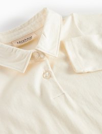 Világosszürke pamut pólóing klasszikus gallérral, két gombbal, finom textúrával és "MarMar Copenhagen" címképzővel.