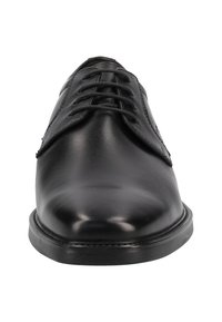 Chaussure en cuir noir avec une texture lisse, bout arrondi et système de laçage à six œillets. Elle dispose d'une semelle en caoutchouc plate et de détails de couture subtils.