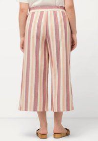 Välja byxor med breda ben i pastellrandigt mönster som har en elastisk midja. Tyget har en mjuk textur med växlande ljusrosa och krämfärg.