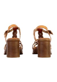 Sandali con tacco marroni, con apertura sul retro, caratterizzati da una fascia in pelle intrecciata e un tacco a blocco testurizzato. Il design è minimale con una fascia regolabile alla caviglia.