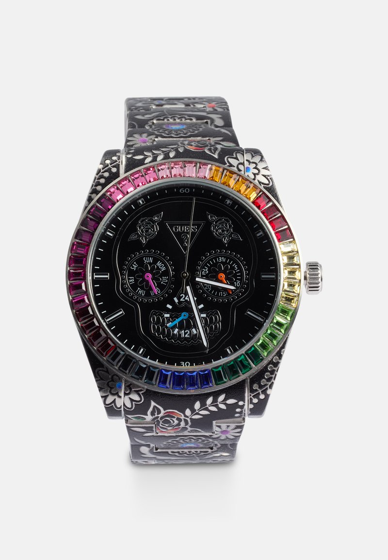 Schwarze Uhr mit Blumenmuster-Armband, Totenkopf-Design-Zifferblatt, drei Unterdials und einer mehrfarbigen Lünette mit rechteckigen Steinen.