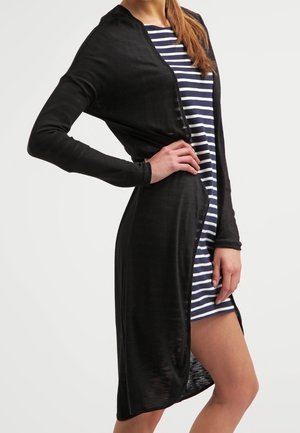 Black, long-sleeved cardigan in lightweight fabric, featuring an open front and side slit, layered over a blue-and-white striped dress.