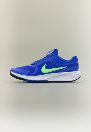 Kék Nike futócipő neon zöld jelzéssel, fehér talppal és fekete mintázattal, semleges háttér előtt, külső oldalról mutatva.