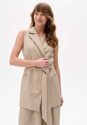 Beige ärmellose Weste mit vertikalen Streifen, einem Wickeldesign und einer gebundenen Taille. Verfügt über Seitentaschen und eine glatte Stofftextur.