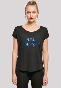 Svart t-skjorte med kort erm laget av mykt stoff, med et sentralt Batman-logo i blått og grått med japansk tekst, avslappet passform.