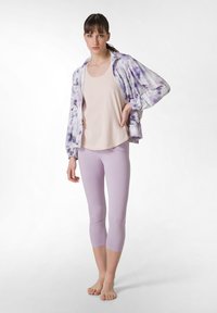 Ljuslila avklippta leggings som matchas med en beige linne och en ljuslila tie-dye zip-jacka. Slät tyg, avslappnad passform, elastisk midja.