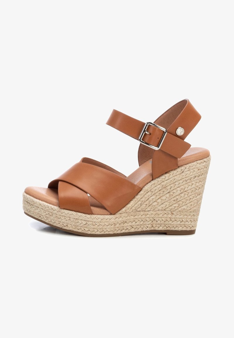 Sandalo wedge in pelle marrone con cinturini incrociati, fibbia alla caviglia e piattaforma in juta intrecciata. Texture liscia e forma della punta arrotondata.
