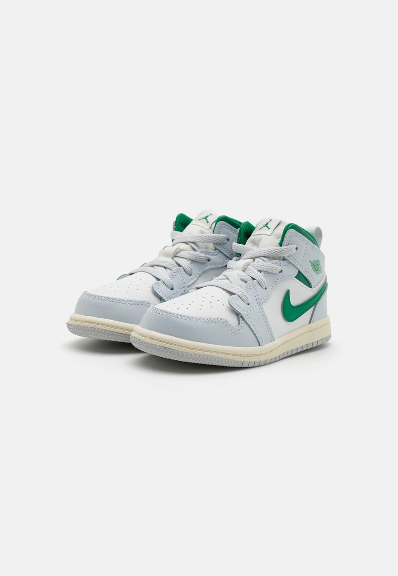 Zapatillas de media caña en blanco con acentos grises. Swoosh y pestaña del talón en verde de Nike. Caja de los dedos perforada, lengua acolchada y suela de goma texturizada.