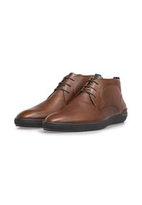 Botines de cuero marrón con un acabado texturizado, puntera redonda y suela de goma negra en contraste. Presenta un diseño de cordones y costuras sutiles.