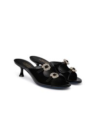Black velvet mules with an open toe, featuring three bejeweled accents, a low curved heel, and a glossy finish on the sole.