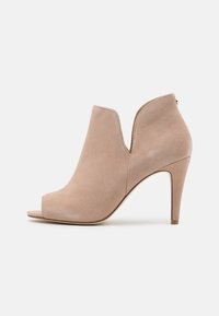Stivaletti beige in suede con design open toe, dettaglio a taglio e alto tacco a stiletto. Texture liscia e silhouette elegante.