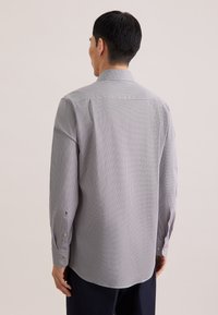 Camicia a maniche lunghe con motivo a quadri grigio e bianco, caratterizzata da un colletto classico, polsini con bottoni e una vestibilità comoda con orlo arrotondato.