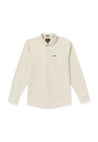 Chemise beige clair à manches longues avec col, poche poitrine unique et texture lisse. Présente une petite étiquette de marque au-dessus de la poche.