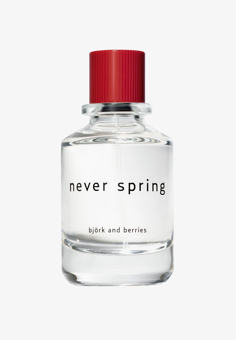 Flacon de parfum en verre transparent avec un bouchon rouge, étiqueté "never spring" et "björk and berries", contenant un liquide transparent.