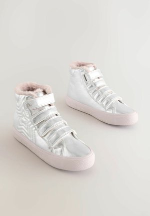 Zapatillas altas de metalizado plateado con cuello forrado de pelo, que presentan cuatro correas elásticas, panel lateral texturizado y suela de goma rosa.