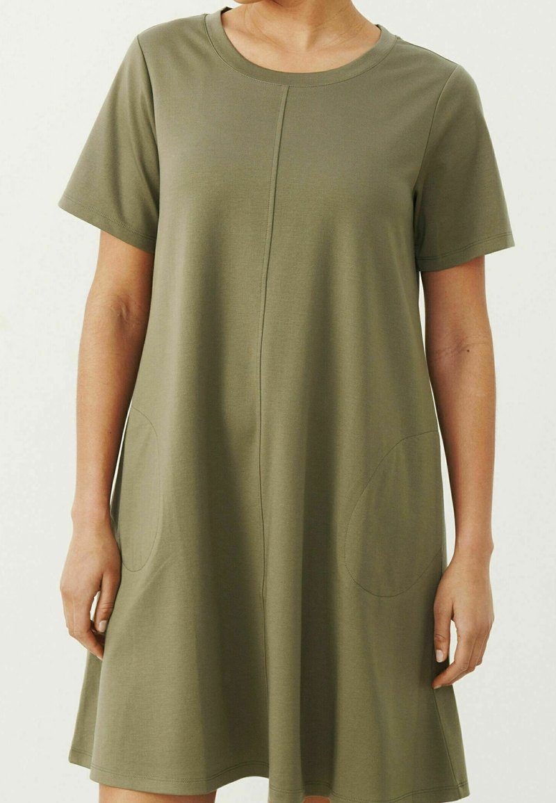 Vestido de manga corta en verde oliva, hecho de una tela suave. Presenta un escote redondo, detalle de costura frontal y dos bolsillos laterales.