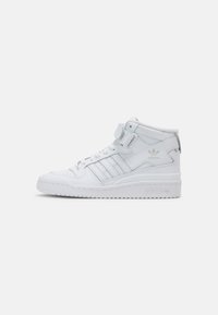 Zapatillas altas blancas de cuero con textura suave, que presentan tres franjas laterales, una correa de Velcro y una suela de goma.
