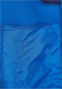 Blue fleece fabric with a smooth blue lining and stitched edges, featuring a zippered pocket on the front side for storage.