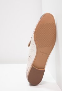 Chaussure plate avec une légère texture de peau de serpent, semelle en caoutchouc marron clair marquée "Parfois 37", positionnée verticalement sur fond blanc.