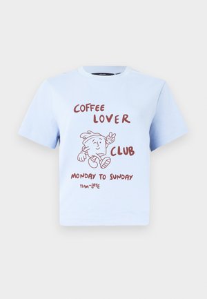 Ανοιχτό μπλε T-shirt με κόκκινο κείμενο "Coffee Lover Club Δευτέρα έως Κυριακή 11 π.μ. - Αργά" και μια καρτούν κούπα καφέ που κάνει χειρονομία ειρήνης.