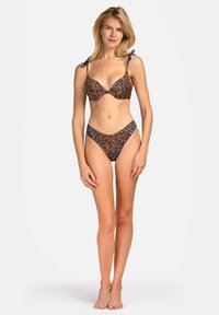 Zestaw bikini z wzorzystej tkaniny w brązowym, niebieskim i kremowym kolorze. Biustonosz ma głęboki dekolt i wiązania na ramiączkach, a dolna część ma wysoki krój.