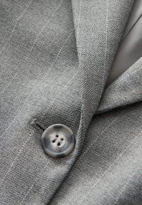 Gray tailored jacket with subtle pinstripe pattern, featuring a round, gray button with four holes, and a smooth inner lining.