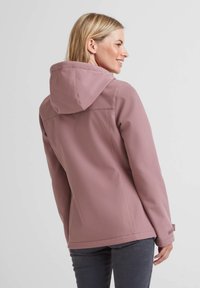 Soft pink waterproof jacket with a hood, front seams, and wrist adjusters, made from smooth, durable fabric. Back view shows fitted design.