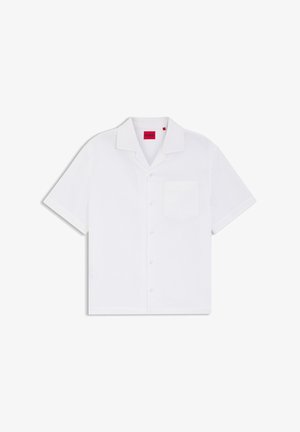 Chemise blanche à manches courtes avec boutons sur le devant, une poche poitrine et une étiquette rouge "HUGO" à l'intérieur du col.