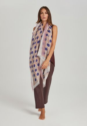 Leichter Schal mit einem durchsichtigen Design und großen blauen Punkten auf einem weichen, rosafarbenen Hintergrund. Die Kanten sind ausgefranst.