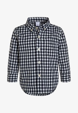 Koszula dziecięca z długim rękawem, zapinana na guziki, w czarno-białą kratę, z kieszenią na piersi z przodu.