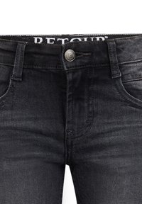 Donkerdenim jeans met een gladde textuur. Beschikt over een klassiek vijf-pocket ontwerp, ritssluiting en een metalen knoop bij de tailleband.