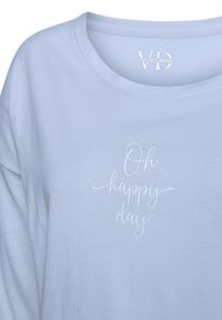 Helles blaues Baumwoll-T-Shirt mit einem runden Halsausschnitt und weißem, geschwungenem Text auf der Vorderseite, der "Oh happy day" liest. Weicher Stoff.