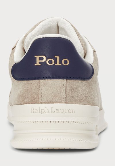 Bež usnjeni športni copat z mornarsko modrim usnjenim petnim pokrovom, zlatim logotipom "Polo" in strukturiranim belim gumijastim podplatom z embosiranim napisom "Ralph Lauren".