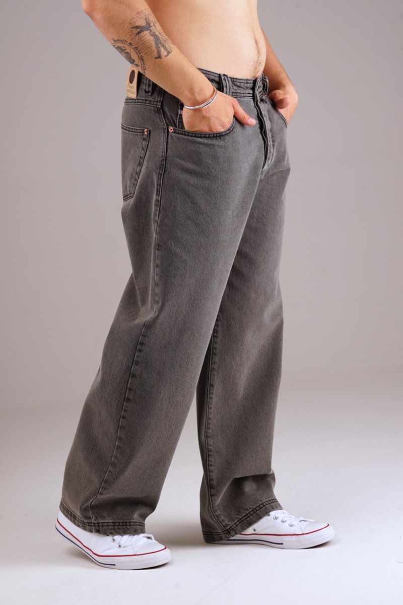 Graue Jeans mit lockerer Passform, ausgestattet mit fünf Taschen und Kupferriegelakzenten. Kombiniert mit weißen Sneakern für einen lässigen Look.