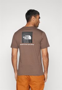 The North Face M SS BOX NSE TEE - T-shirts print - smokey brown/black
