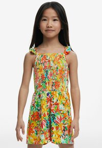 Färgglad blommig jumpsuit med en smockad bodice, volangärmar och livliga mönster i orange, gult, grönt och rosa.