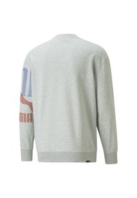 Sudadera gris con mangas largas, cuello redondo y letras texturizadas en rojo y azul en la manga izquierda. Hecha de una tela suave y gruesa.