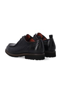 Zwarte leren schoenen met een gladde afwerking, gestructureerd ontwerp, ronde neus en lage rubberen zool, met een contrasterende bruin randafwerking.