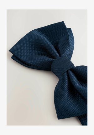 Papillon blu navy realizzato in tessuto tessuto testurizzato, caratterizzato da una forma a farfalla ampia con un nodo centrale elegante. Finitura liscia con motivi sottili.