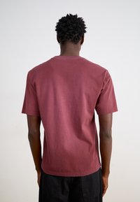 Kortærmet burgunder t-shirt i bomuld med rund halsudskæring, glat tekstur og uden synlige logoer eller mønstre, set bagfra.