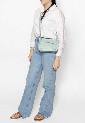 Sac bandoulière en cuir vert menthe de forme rectangulaire, avec des accessoires dorés et une surface texturée. Bandoulière réglable et rabat supérieur avec fermoir.