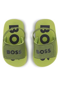 Zelené sandále s nastaviteľnými popruhmi. Obsahujú výrazné čierne logo "BOSS" na vnútornom podklade. Hladký povrch, plochá podrážka a polstrovaná stielka.
