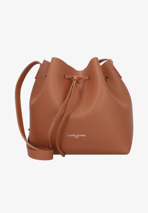 Braune Leder-Eimer-Tasche mit weicher Textur, Zugverschluss und verstellbarem Schultergurt. "Lancaster Paris"-Logo auf der Vorderseite geprägt.