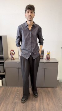 Camicetta a righe bianche e nere con bottoni e maniche arrotolate, abbinata a pantaloni larghi neri e scarpe nere. Decorazioni di sfondo minimalistiche.