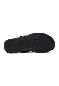Black rubber sole with a wavy tread pattern, designed for traction; features a wide base and rounded edges for stability.