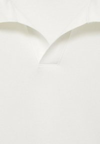 Poloshirt van witte stof, voorzien van een V-hals en korte kraag. Textuurweving zichtbaar, met strakke lijnen en zonder extra patronen of hardware.
