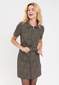 Robe à manches courtes avec un col, tissu noir avec un petit imprimé léopard beige, fermeture éclair à l'avant et taille froncée.