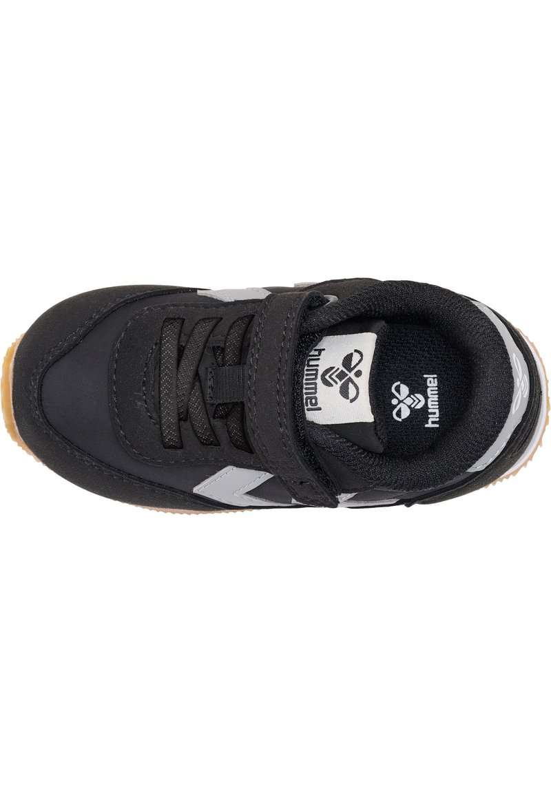 Chaussure de sport noire avec un bout arrondi, présentant un dessus texturé, des accents gris, une bande Velcro et une semelle extérieure en caoutchouc gomme.