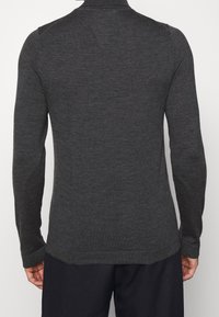 Pull-over à manches longues gris foncé en tissu tricoté doux avec un col côtelé et une légère texture. Coupe ajustée et finition lisse à l'ourlet.