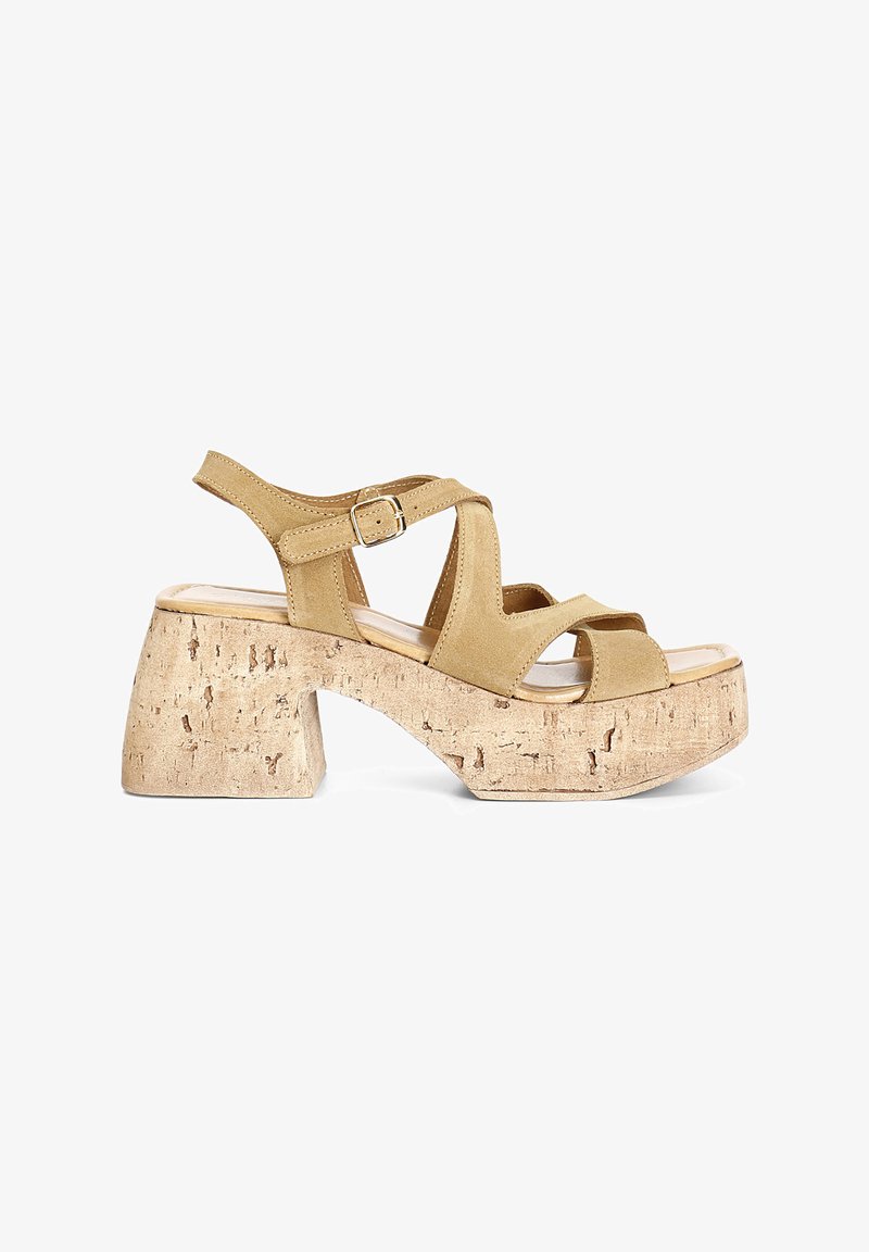 Sandales plateforme en suède beige avec un talon en liège, présentant des brides croisées et une sangle de cheville réglable avec une boucle.